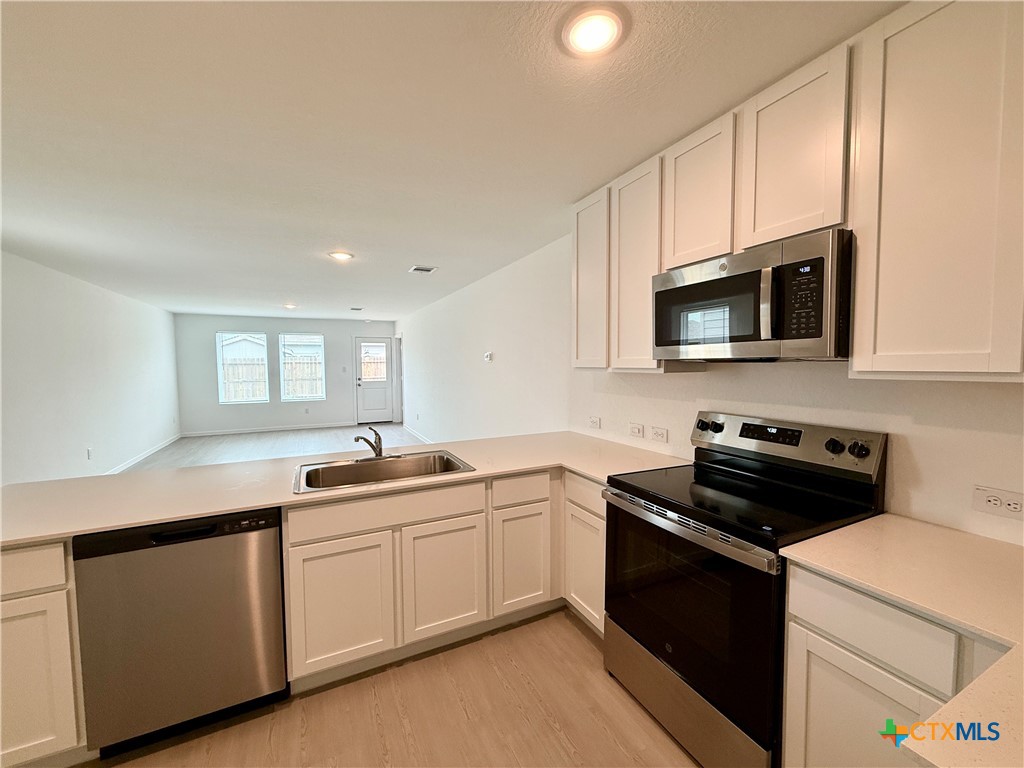 413 Moscato Road New Braunfels, TX 78130 - Photo 7 of 28 a kitchen with a sink stove and microwave