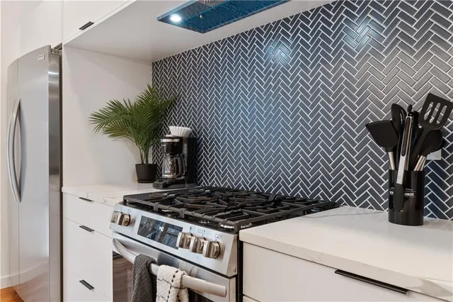 a kitchen with a sink a stove and chairs