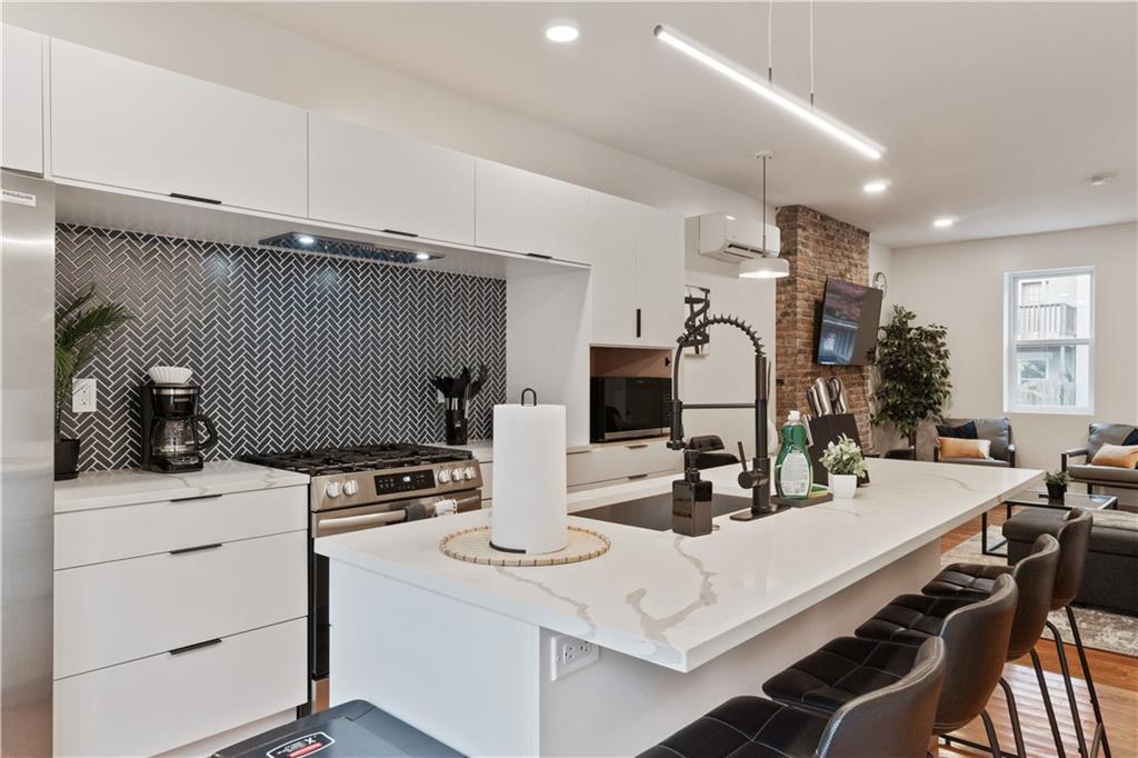 1238 Butterfield Way Pittsburgh, PA 15212 - Photo 13 of 25 a kitchen with a sink a stove and chairs