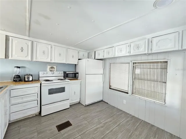 a kitchen with cabinets stainless steel appliances and a window