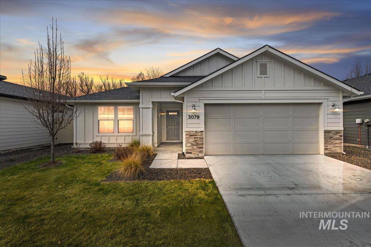 3079 S Green Boise, ID 83709 - Photo 1 of 35 View of front of home featuring board and batten siding, stone siding, concrete driveway, and an attached garage