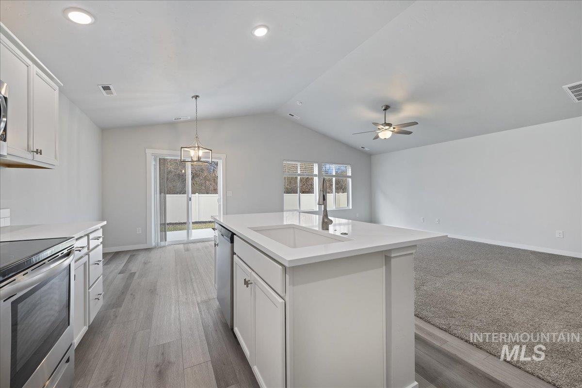 3079 S Green Boise, ID 83709 - Photo 35 of 35 Kitchen featuring white cabinets, stainless steel appliances, open floor plan, and pendant lighting