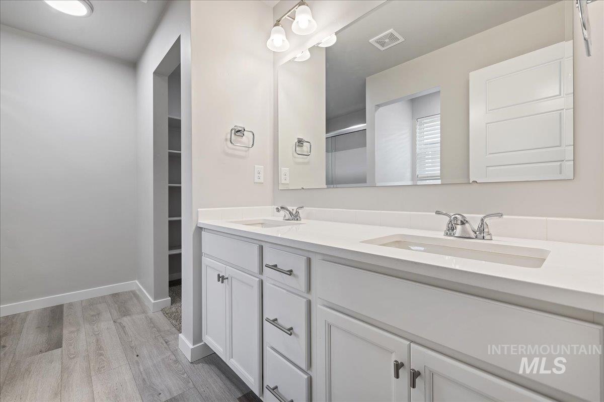 3079 S Green Boise, ID 83709 - Photo 24 of 35 Bathroom featuring double vanity, light wood finished floors, and a walk in closet