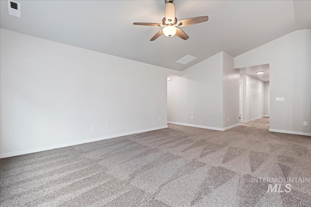 3079 S Green Boise, ID 83709 - Photo 7 of 35 Spare room with vaulted ceiling, a ceiling fan, and light colored carpet