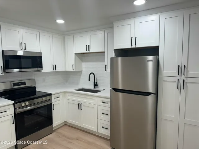 a kitchen with cabinets stainless steel appliances and a counter space