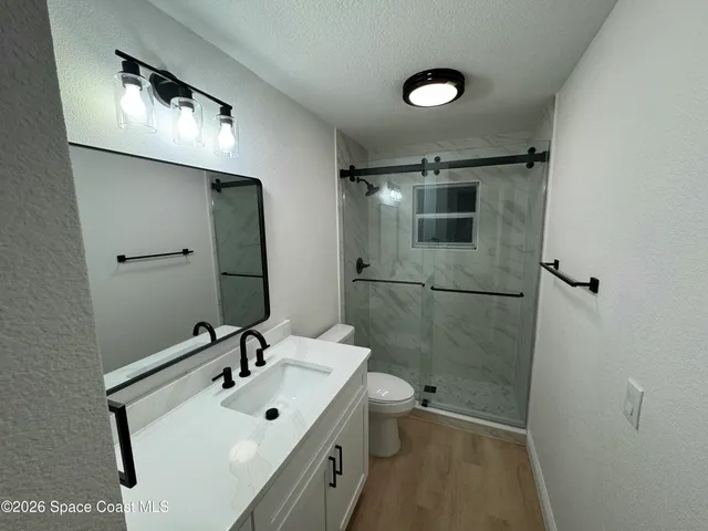 a bathroom with a sink a toilet and shower