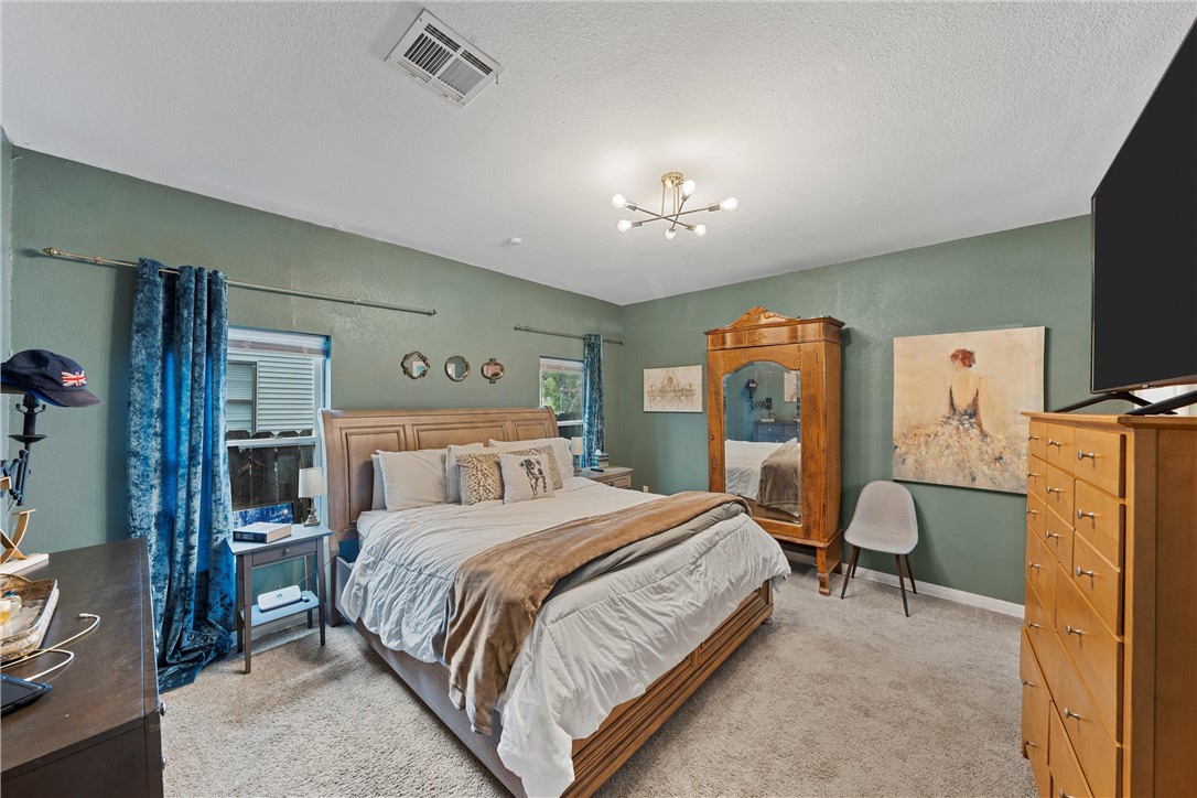 2923 Live Oak Avenue Waco, TX 76708 - Photo 16 of 22 a bedroom with a bed and a chandelier