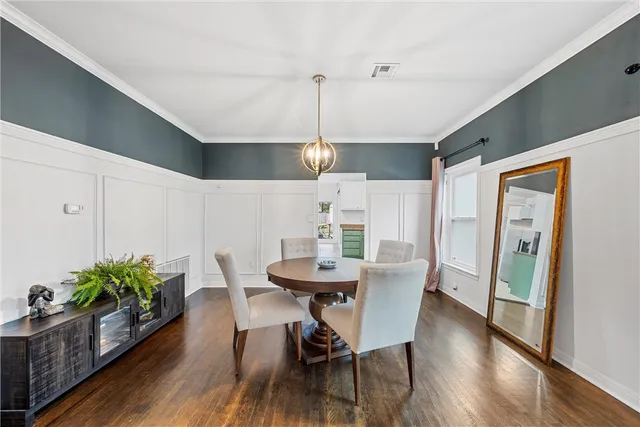 a dining room with furniture potted plants and wooden floor