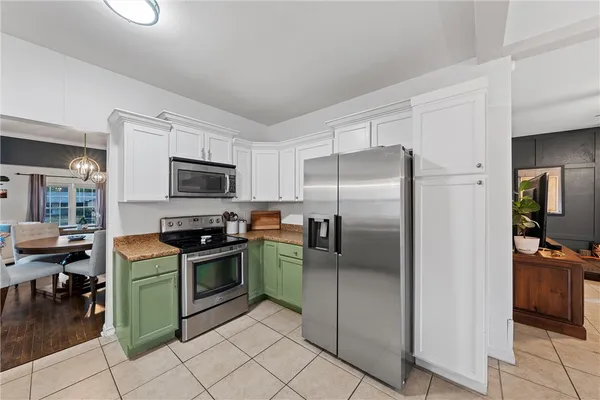 a kitchen with granite countertop a refrigerator and a stove top oven