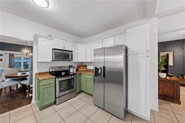 a kitchen with granite countertop a refrigerator and a stove top oven
