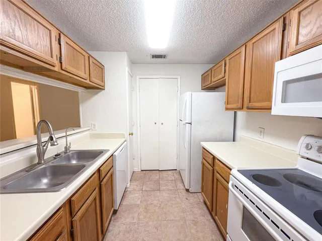 a kitchen with a sink stove top oven and cabinets