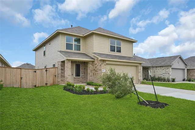 a front view of a house with a yard and trees