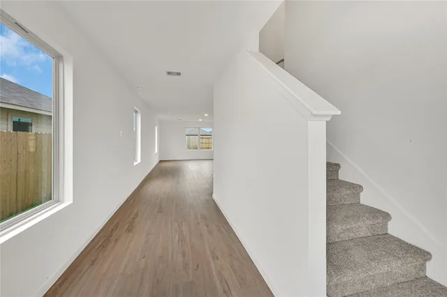 a view of a hallway with wooden floor and staircase