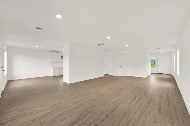 a view of empty room with wooden floor and window