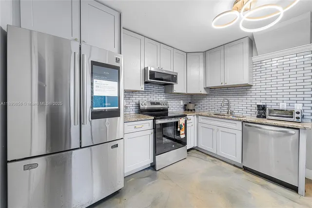 a kitchen with stainless steel appliances granite countertop a refrigerator sink and stove