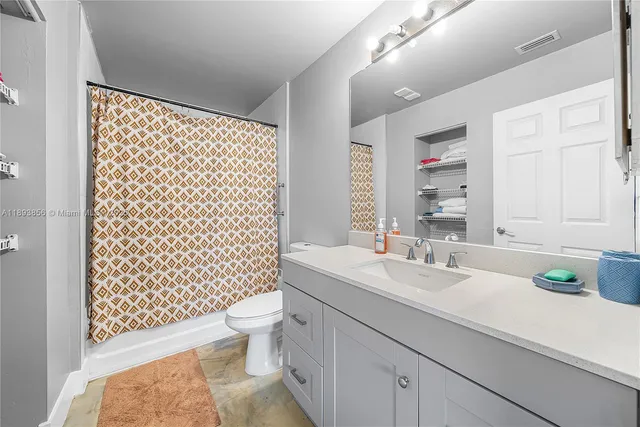 a bathroom with a sink a toilet and shower curtain