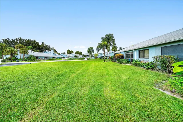 a backyard of a house with table and chairs and potted plants