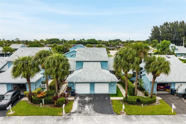 an aerial view of a house with a yard and lake view