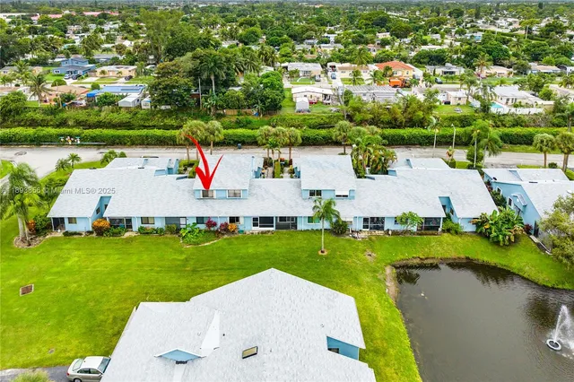 an aerial view of a house with outdoor space and lake view in back