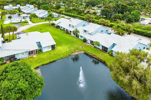 an aerial view of a house with a yard and lake view