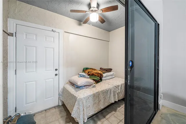 a bedroom with a bed and a ceiling fan