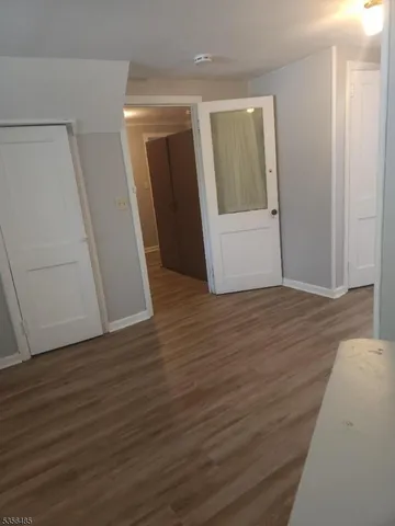 an empty room with wooden floor and mirror