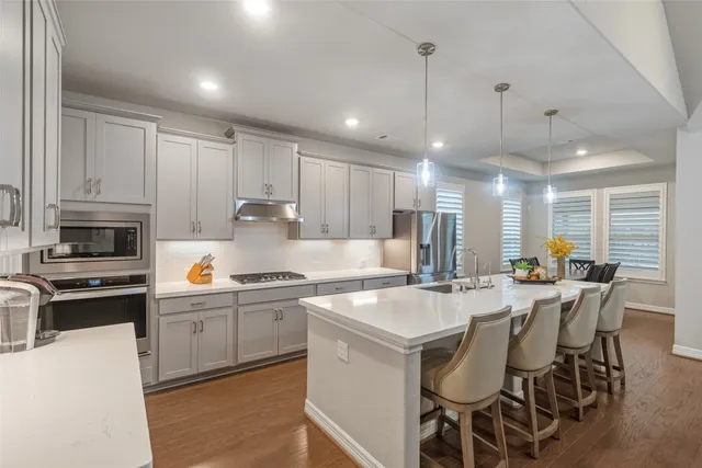 a kitchen with appliances a sink and cabinets