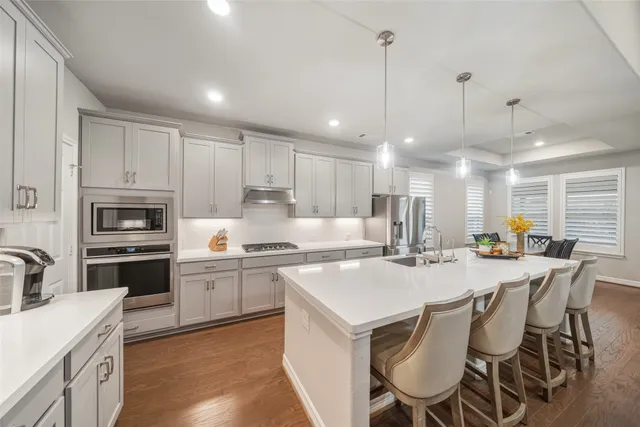 a kitchen with appliances a sink and cabinets