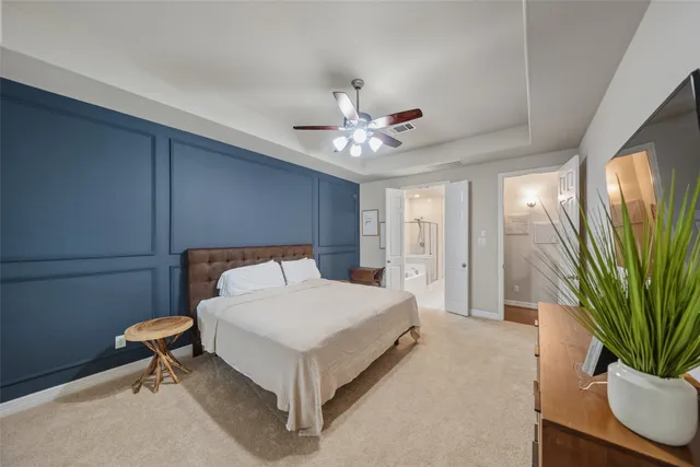 a spacious bedroom with a bed and a potted plant