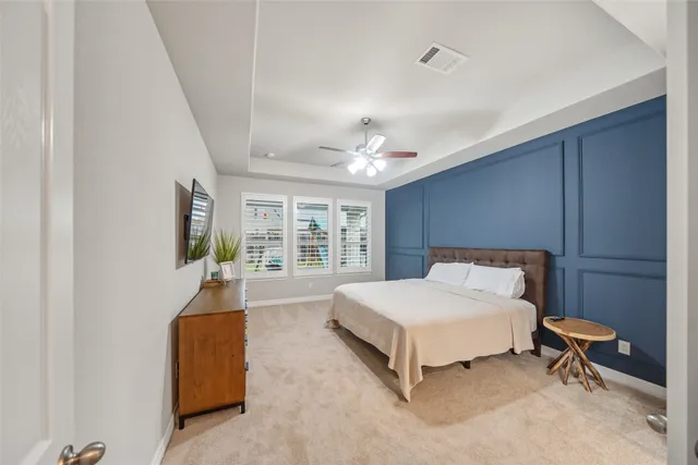 a spacious bedroom with a bed and a chandelier