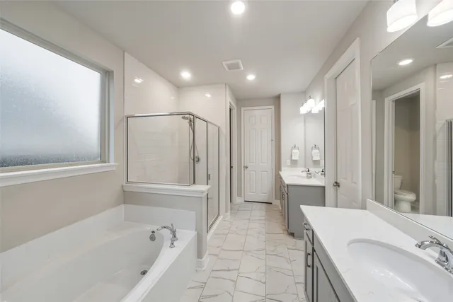 a bathroom with a granite countertop sink a mirror a bathtub and shower