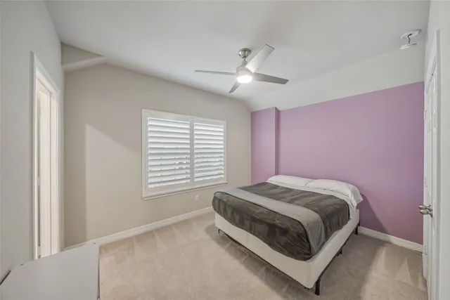 a bed room with a bed and a ceiling fan