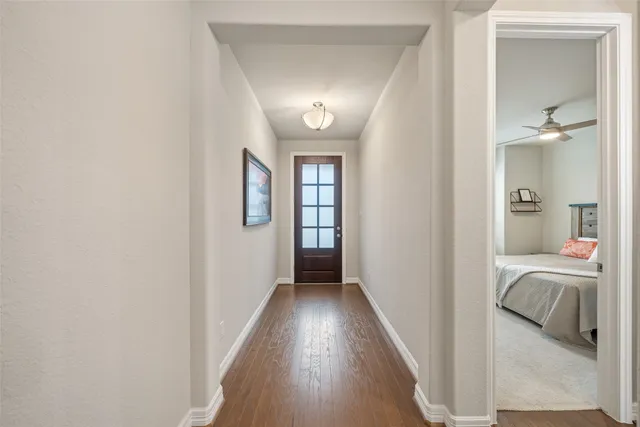 a view of a hallway with wooden floor and furniture