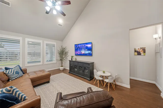 a living room with furniture a flat screen tv and a large window