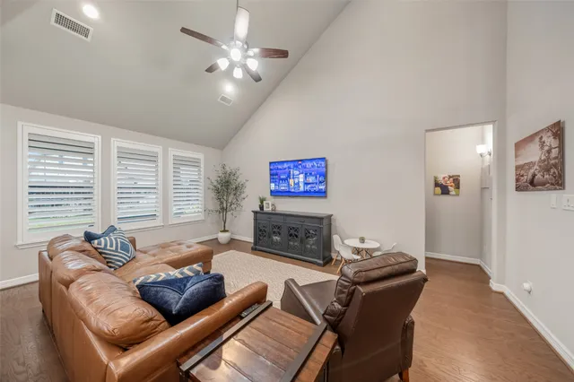 a living room with furniture a ceiling fan and a window