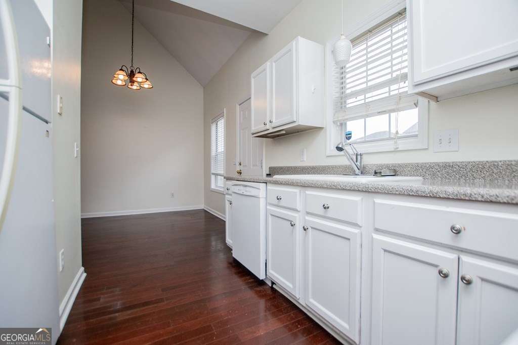 255 Morgan Road Carrollton, GA 30116 - Photo 16 of 57 a kitchen with granite countertop a stove a sink and white cabinets with wooden floor