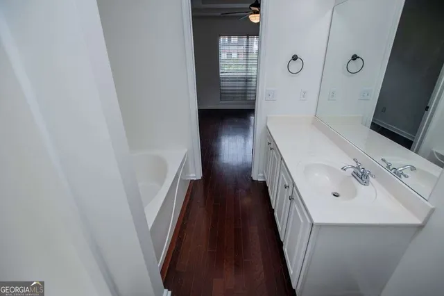 a en suite bathroom with a sink a mirror a toilet and a window