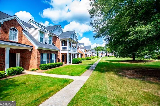 a view of a brick house with a yard