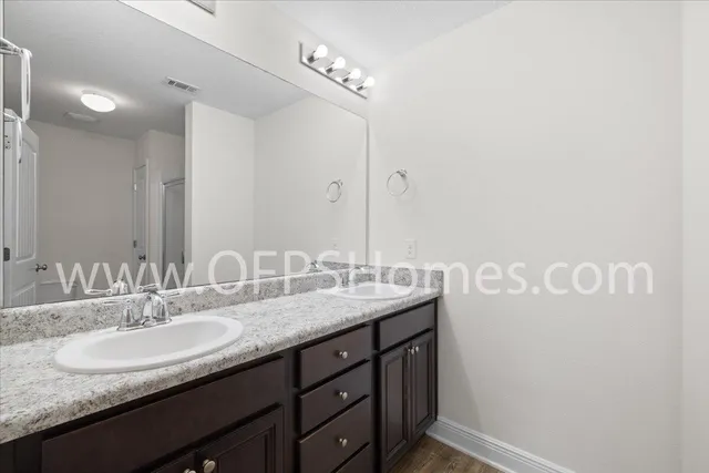 a bathroom with a granite countertop sink and a mirror