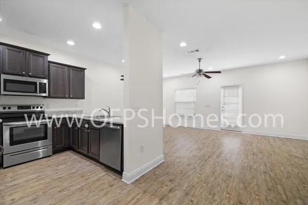 a kitchen with stainless steel appliances granite countertop a stove and a wooden floors