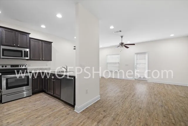 a kitchen with stainless steel appliances granite countertop a stove and a wooden floors