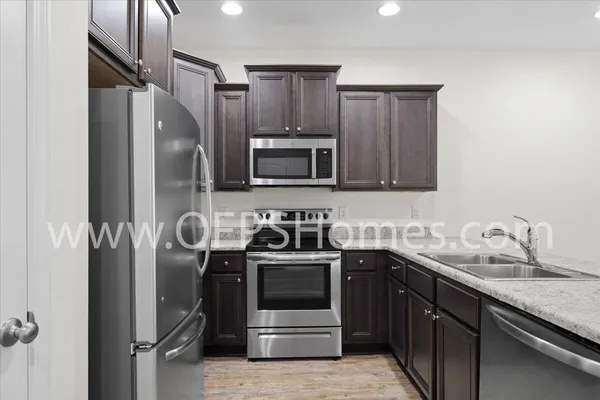 a kitchen with stainless steel appliances granite countertop a sink stove and refrigerator