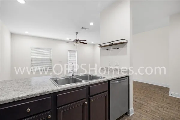 a kitchen with granite countertop a sink and a wooden floor