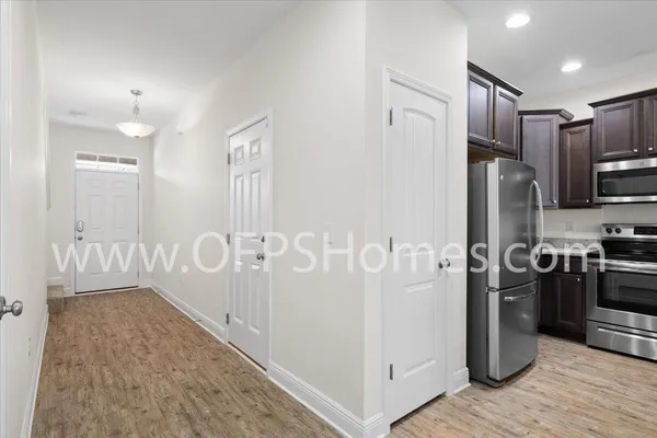 a kitchen with stainless steel appliances granite countertop a refrigerator a stove and a sink