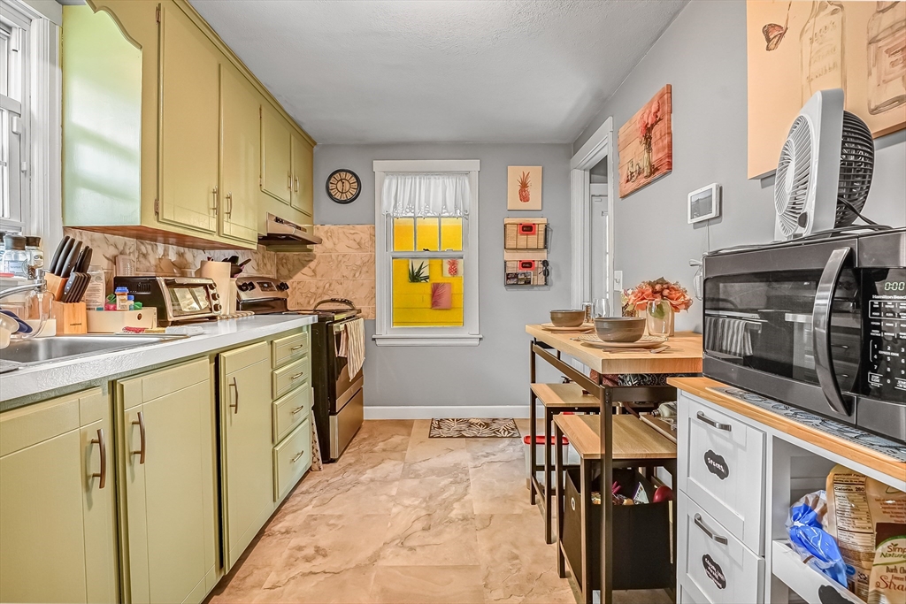 90 Roanoke Road Springfield, MA 01118 - Photo 8 of 19 a kitchen with stainless steel appliances granite countertop a stove a sink and a microwave