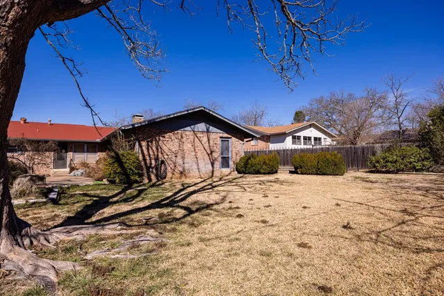 a street view with wooden fence and plants