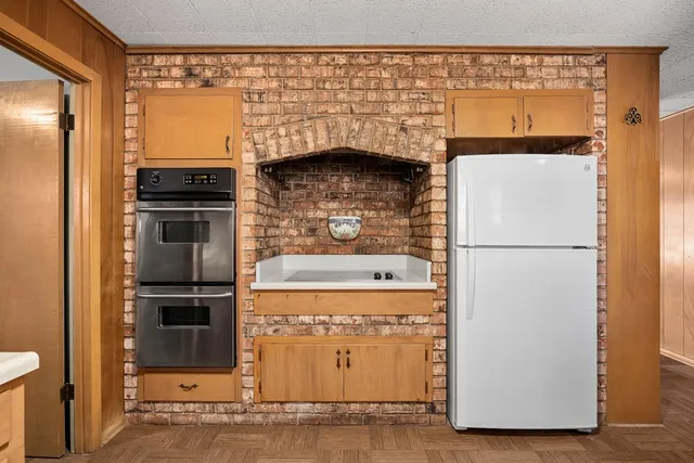a view of open kitchen with granite countertop a refrigerator and a stove