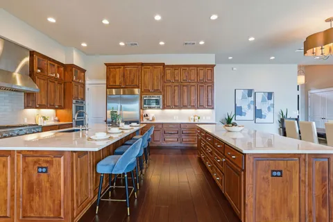 a kitchen with stainless steel appliances granite countertop a sink a stove and a refrigerator