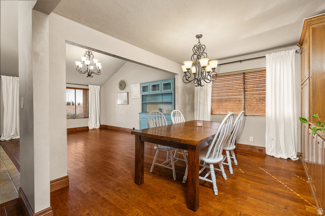 892 Cambridge Drive St. George, UT 84770 - Photo 29 of 65 Open concept dining area featuring wood-finish flooring, a decorative chandelier, and a built-in blue cabinet with glass doors