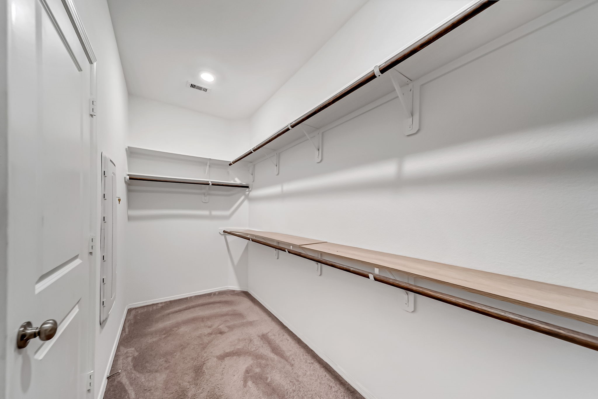 2847 Mistygate Court Conroe, TX 77301 - Photo 17 of 27 This spacious walk-in closet features multiple shelves and hanging rods, ideal for organizing clothing and accessories efficiently. The neutral carpet and lighting create a clean, inviting space.